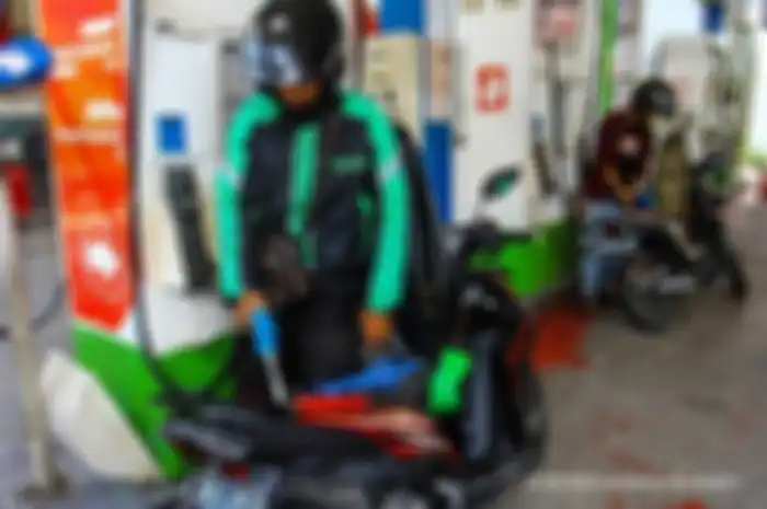 Ilustrasi driver ojol mengisi BBM Pertamax pada motornya.