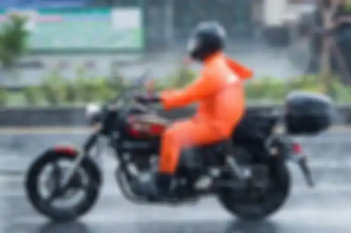 Ilustrasi berkendara pakai jas hujan. Ini jas hujan yang aman untuk pemotor.