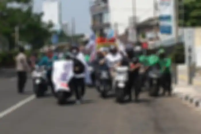 Aksi massa buruh dorong motor menuju Balai Kota Depok saat demo tolak harga Pertalite naik, Kamis (1592022)