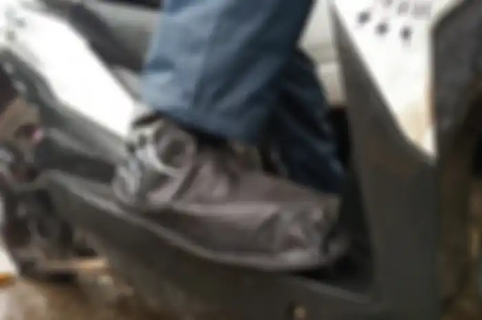 Ilustrasi cover sepatu saat naik motor. Masuk musim hujan, pemotor siapkan cover sepatu anti air harga mulai Rp 10 ribu.