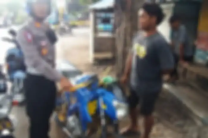 Polisi melakukan penindakan terhadap pemotor yang melipat pelat nomor motornya.
