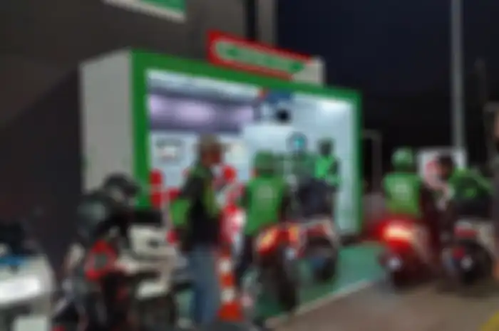 Foto ilustrasi. Beberapa driver ojol sedang menukar baterai motor listrik.