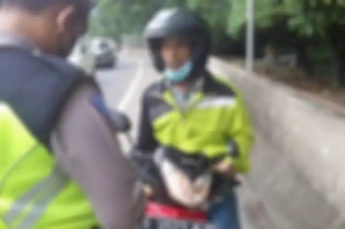 Pemotor Honda Supra X 125 diberhentikan polisi usai terabas masuk jalan tol.