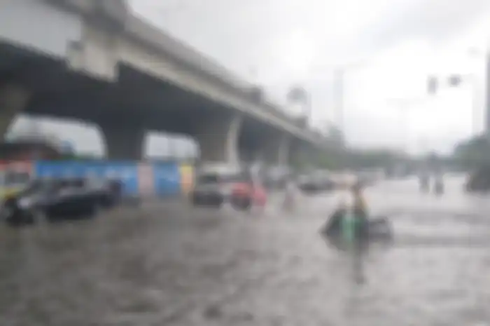 Ilustrasi pemotor melaju saat banjir di Jakarta hari ini, Minggu (1/1/2023).