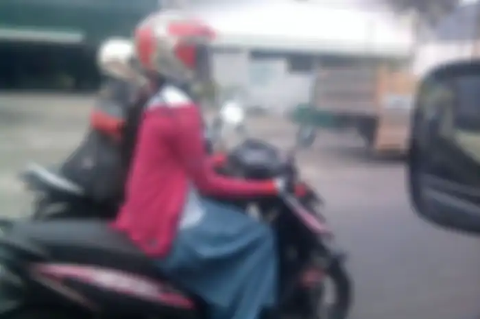 Ilustrasi perempuan memutar gas motor dengan tangan terbalik. Bahaya dan tidak berpengaruh pada kecerahan kulit. 