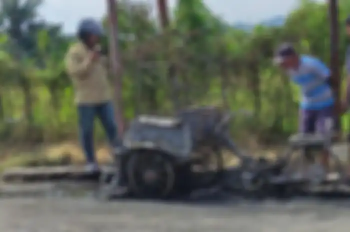 Becak Motor angkut BBM Pertalite terbakar, pengemudi sedang merokok.