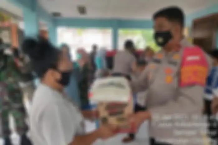 Potret purnawirawan polisi Eko Setio Budi Wahono membagikan bansos semasa menjabat sebagai Kapolsek Cilincing.