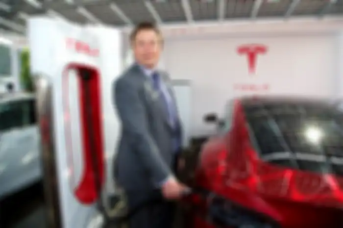 CEO Tesla, Elon Musk sedang mengisi daya mobil listrik Tesla