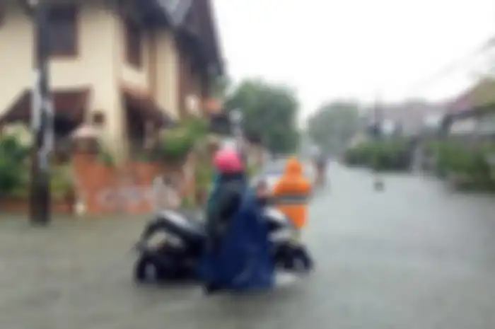 Motor matic mogok menerjang banjir di Kota Makassar, Sulawesi Selatan, Senin (13/2/2023).