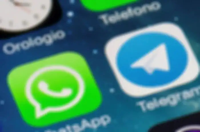 Ilustreasi logo WhatsApp dan Telegram di smartphone