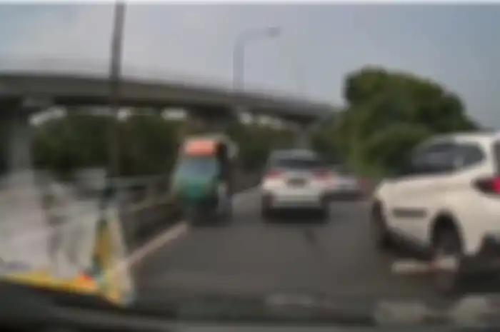 Pengemudi mobil kaget mendadak motor roda tiga masuk jalan tol dan lawan arus, sangat berbahaya.