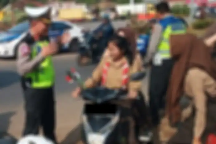 Ilustrasi polisi di Lampung melakukan tilang manual ke pemotor yang melanggar lalu lintas.