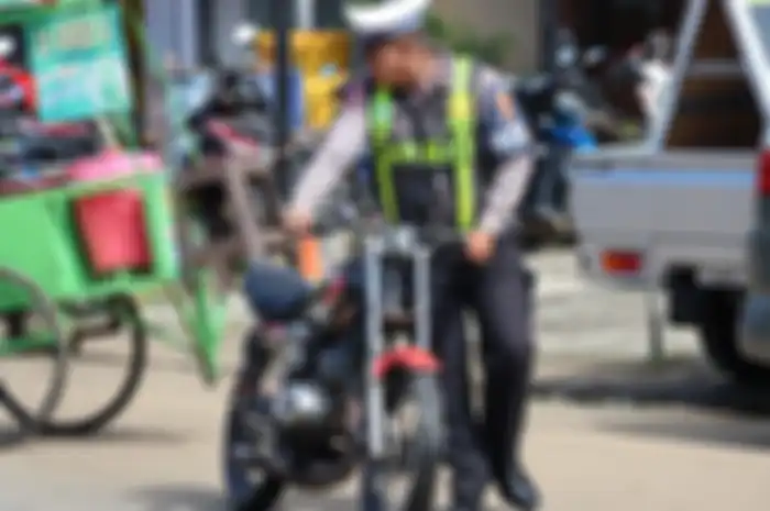 Seorang petugas polisi mengamankan motor dalam razia operasi April kemarin