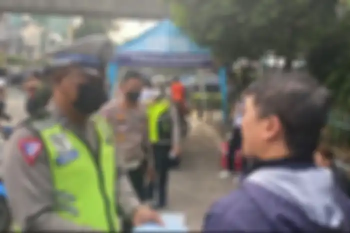 Ilustrasi polisi tilang pengendara motor yang belum uji emisi di Jakarta.