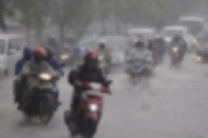 Ilustrasi berkendara motor saat hujan.
