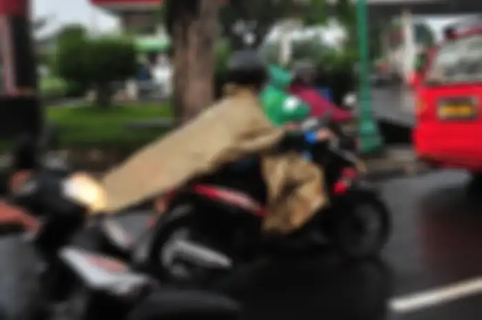 Pakai jas hujan ponco bukan cuma bikin nyawa terancam, tapi bisa menutupi lampu sein.