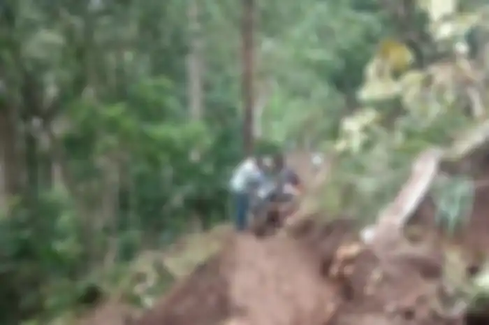 Jalan longsor bikin motor tidak bisa melintas. Warga bikin jasa gotong motor dengan tarif Rp 20 ribu