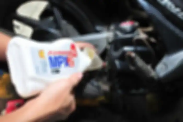 Ilustrasi penggantian oli mesin motor.
