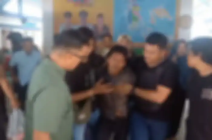 Suami yang membunuh istrinya sendiri di Karimun Kepulauan Riau (Kepri), Iwan (kemeja kotak), saat digiring polisi, Minggu (5/5/2024).