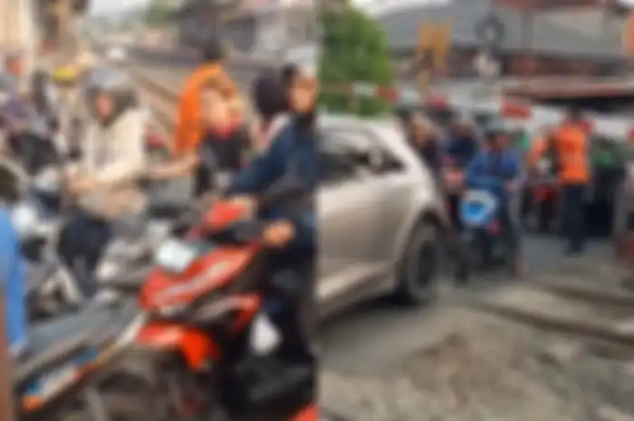 Banyak pemotor terjebak macet di tengah palang pintu kereta api.