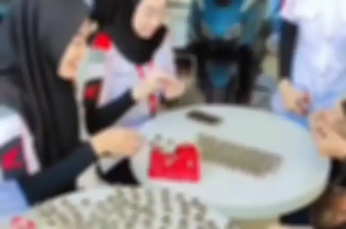 Momen penghitungan uang koin oleh karyawan dealer dari suami istri yang beli motor baru Honda BeAT di Probolinggo.