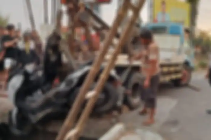 Proses evakuasi Yamaha XMAX yang masuk selokan usai pemotor terjerat kabel fiber optik di Tulungagung, Jawa Timur, Minggu (8/9/2024). 