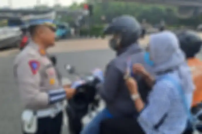 Pemotor tidak menggunakan helm mendapat imbauan dari polisi di Kawasan Traffic Light Halim Baru, Jakarta Timur, Selasa (15/10/2024).