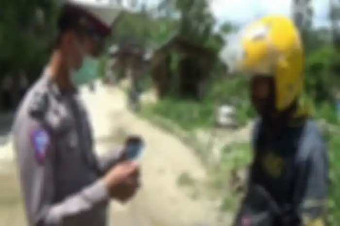 Foto ilustrasi polisi cek SIM dan STNK pemotor di jalan tikus.