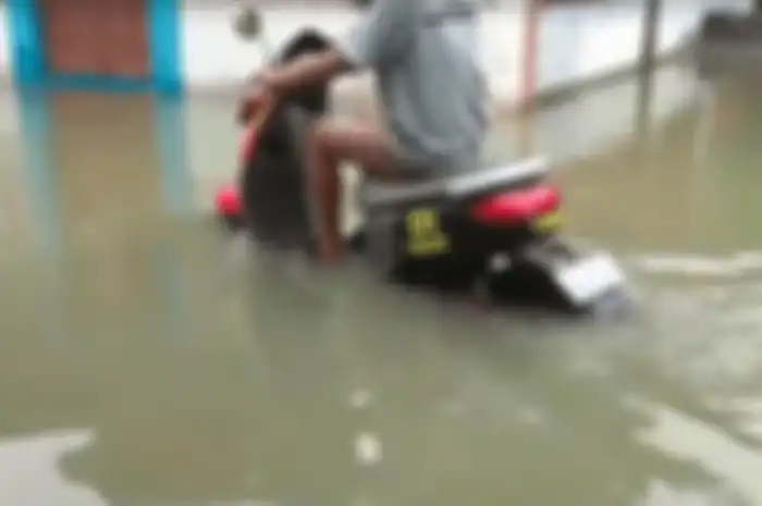 Hujan deras sejak Senin (3/3) sampai Selasa (4/3) menyebabkan banjir, motor listrik tetap bisa lewati genangan air.