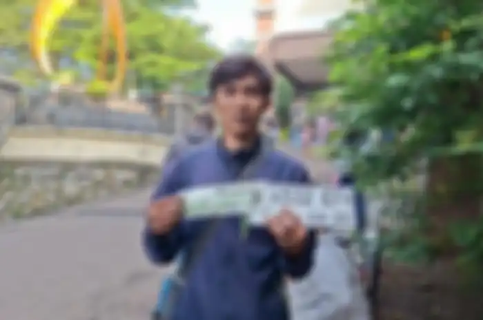 Wahyu Romadhona menunjukkan pelat motor dan STNK baru usai mengurus pemutihan pajak kendaraan di Kantor Samsat Depok, Rabu (25/6/2025). Meski sudah 13 tahun menunggak pajak, dirinya hanya membayar pajak motornya sebesar Rp 290.000.