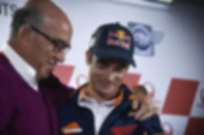  CEO Dorna Sport, Carmelo Ezpeleta (kiri), merangkul Dani Pedrosa saat sang pembalap mengumukan pensiun