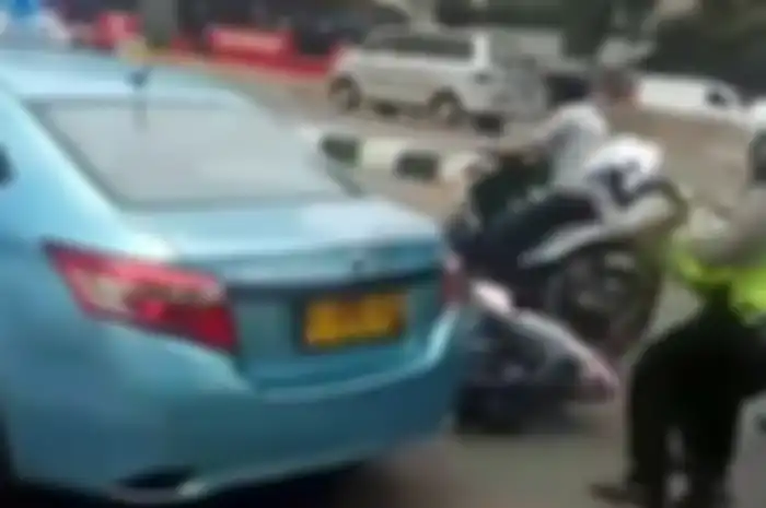 Seorang polisi terjungkal diserempet taksi.