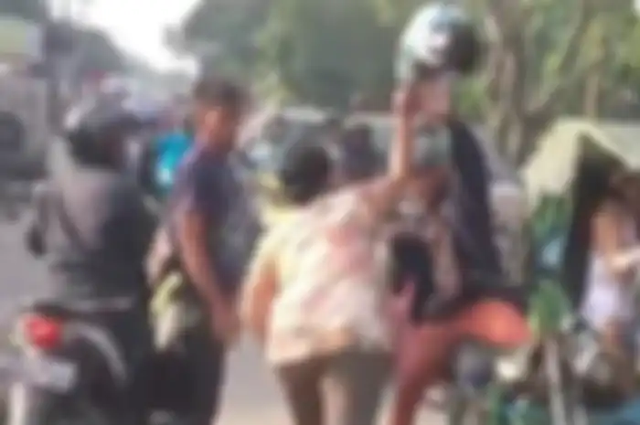 Emak-emak hajar pengendara motor pakai helm.