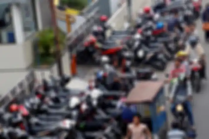 Ilustrasi motor parkir sembarangan sehingga membuat sebagian jalan tertutup.