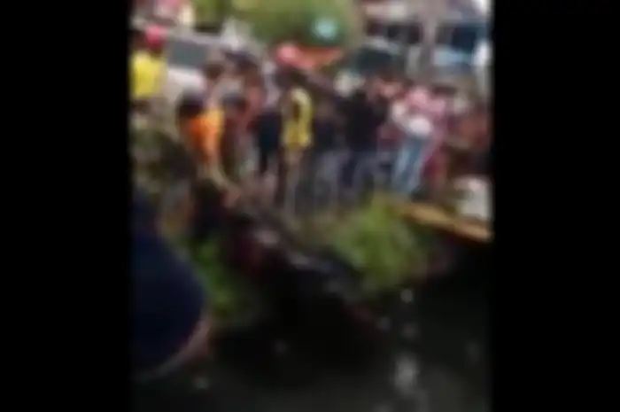 Warga saling bantu saat mengangkat motor dari dasar sungai