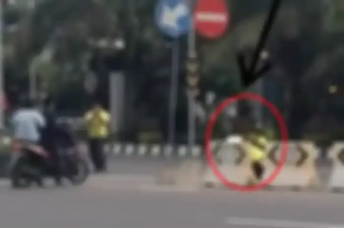 Polisi sembunyi dibalik pembatas jalan, seperti siluman.
