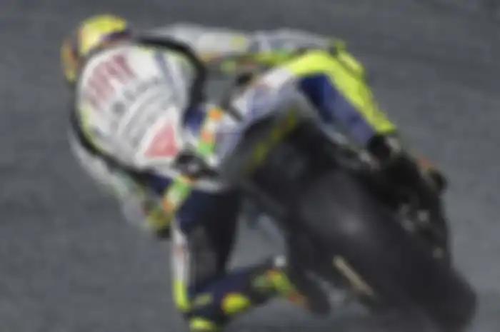 Jas hujan pembalap MotoGP dibuat transparan agar iklan tetap terlihat.