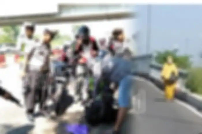 Seorang wanita bergamis kuning terpaksa berjalan saat ada razia di pintu keluar Jembatan Suramadu, Madura 