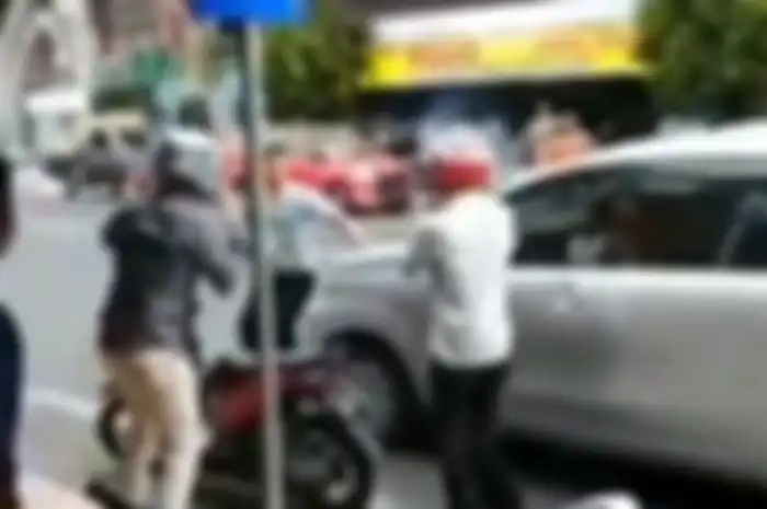 Pemotor dan pengendara mobil terlibat keributan setelah terjadi senggolan.