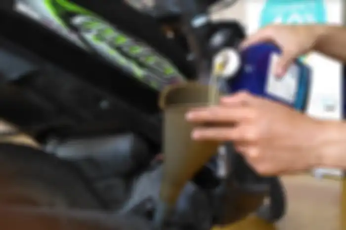 Ilustrasi ganti oli motor matic.