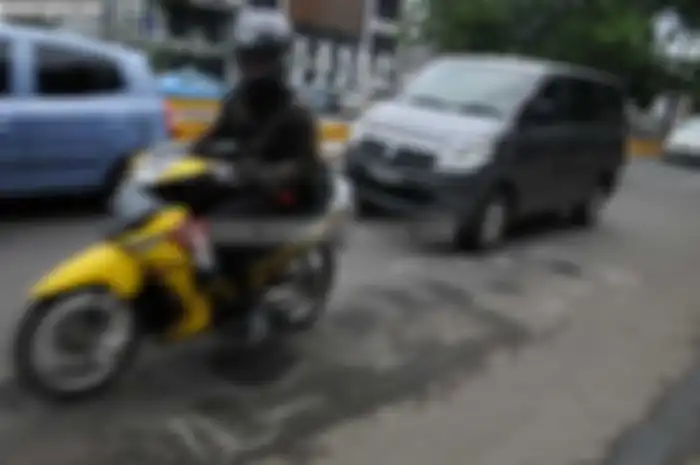 Musim hujan jalan harus ekstra hati-hati karena banyak lubang yang tertutup air.