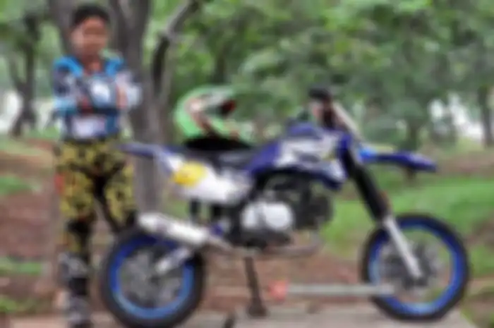 Bro Putu cinta olahraga garuk tanah. Nah, ia coba menurunkan hobinya itu pada sang anak. Caranya membekali Honda Supra Fit yang disulap jadi trail mini. Hasilnya tidak sia-sia, beberapa kalo dengan Honda Supra Fit desain trail mini sang