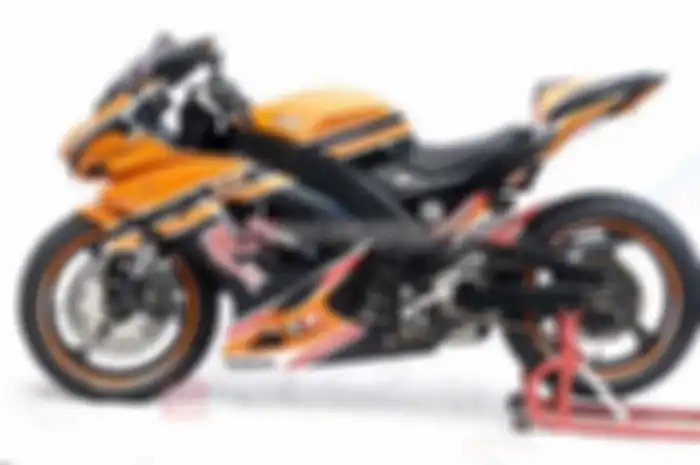 Material fiberglass, diracik untuk semua komponen bodi. Bentuknya serba melengkung agar terkesan gambot. Mulai dari bodi depan, fairing hingga bodi belakang. “Termasuk deltabox kamuflase, dibuat dari fiberglass. Desainnya menyerupai Honda CBR 600, ya