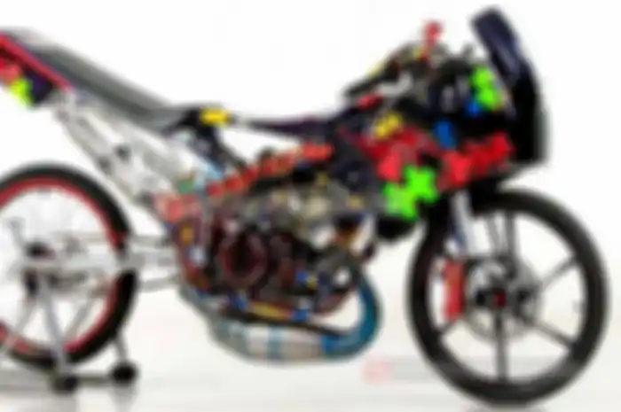 Tau lagu ‘Ada Pelangi di Bola Matamu’ gak sob? Yup, itu lagu yang dinyanyikan grup band Jamrud. Tapi, pelangi yang satu ini bukan di bola mata. Melainkan di frame Kawasaki Ninja 150R racing look garapan bengkel Gode Art di bilangan Jakarta Pusat. Ron