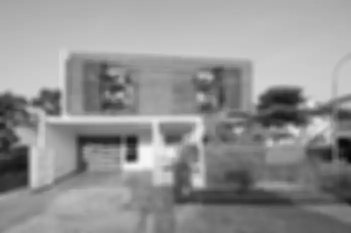 Tampak depan rumah dengan fasad yang didominasi material bata merah.