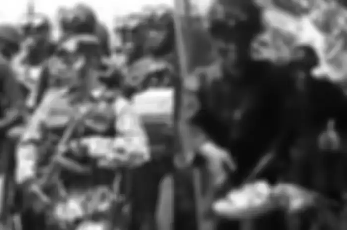 Para anggota TNI AU melewati rumah warga yang tengah mengadakan pesta pernikahan.