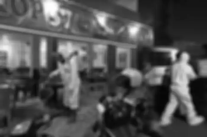 Anggota Tim Kimia Biologi Radioaktif (KBR) Gegana Brimob Polda Jatim menyemprotkan cairan disinfektan ke sebuah warkop berlokasi di Jalan Raya Gunungsari I, Wonokromo, Surabaya, serta membawa pengunjung yang positif Covid-19 ke mobil ambulans 