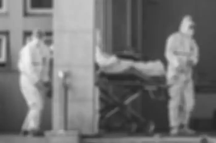 Petugas medis membawa seorang pasien yang diduga terinfeksi virus misterius mirip SARS, ke rumah sakit Jinyintan, di Kota Wuhan, China, Sabtu (18/1/2020).
