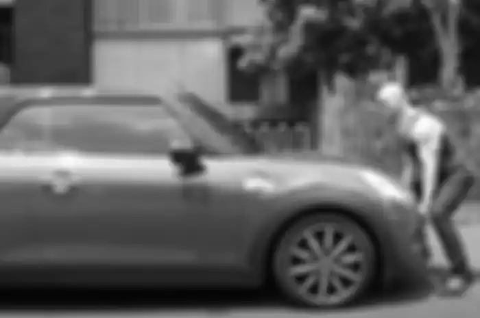 Aksi Deddy Corbuzier saat mencoba mengangkat Mini Cooper dengan tangan kosong