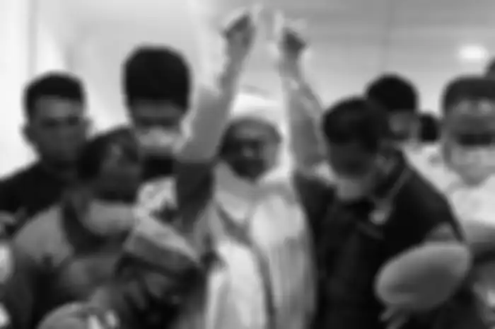 Pemimpin Front Pembela Islam (FPI) Muhammad Rizieq Shihab mengenakan baju tahanan seusai menjalani pemeriksaan di Polda Metro Jaya, Jakarta Pusat, Minggu (13/12/2020) dini hari. 